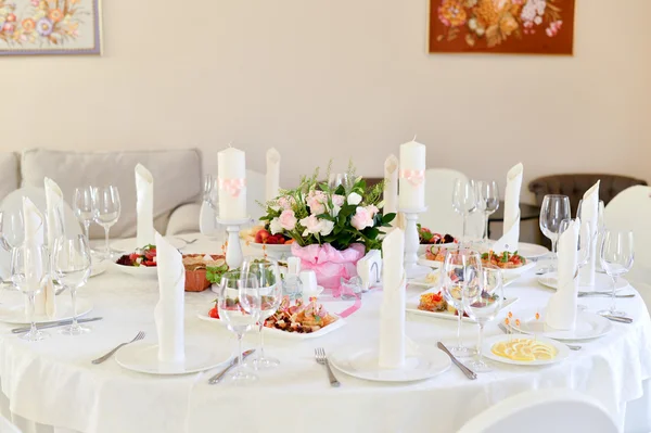 Wedding table setting decoration, candle holder, white candle, flowers.