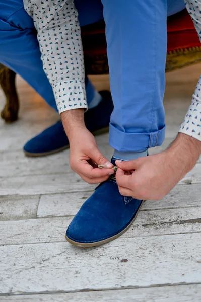 Mężczyzna wiązania sznurowadeł w niebieskie buty — Zdjęcie stockowe