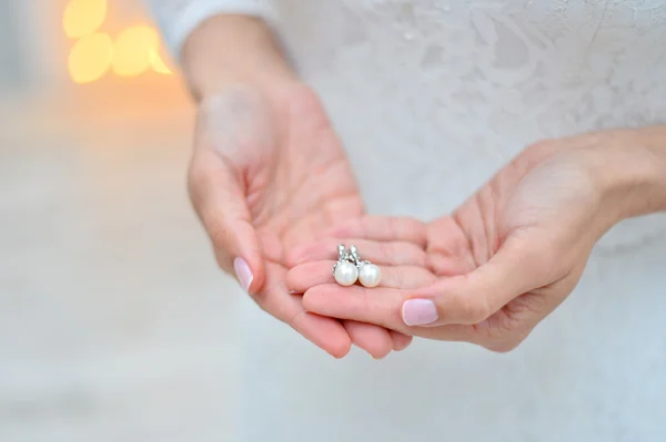 Pearl earring in hands — Stock Photo, Image