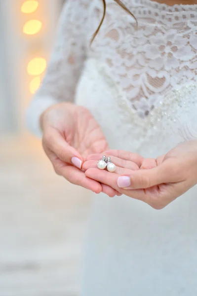 Pendientes de perlas en las manos —  Fotos de Stock