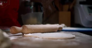 Ev yapımı hamur tatlısı için ahşap broşla un ve hamurun tozlanması