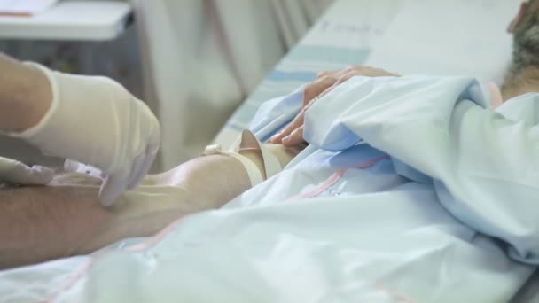 Медсестра вставляет капельницу пациенту — стоковое видео