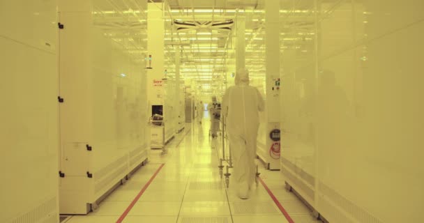 Trabajadores con trajes limpios en una instalación de fabricación de semiconductores — Vídeos de Stock