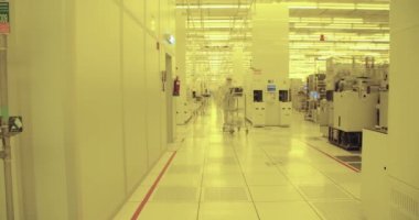 İşçiler temiz elbiseli bir yarı iletken üretim tesisi