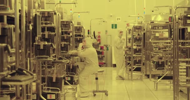 Trabajadores con trajes limpios en una instalación de fabricación de semiconductores — Vídeos de Stock