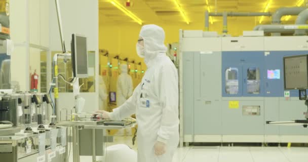 Werknemers in schone pakken in een halfgeleider fabricage faciliteit — Stockvideo