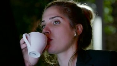 Bir dizüstü bilgisayarda çalışarak ve telefon görüşmeleri yapan iş kadını