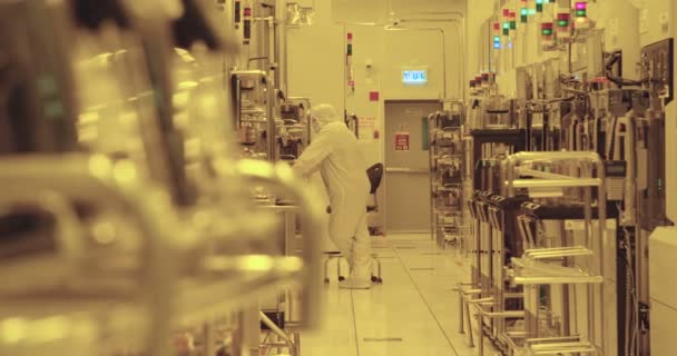 Trabajadores con trajes limpios en una instalación de fabricación de semiconductores — Vídeos de Stock