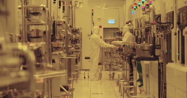 Trabajadores con trajes limpios en una instalación de fabricación de semiconductores — Vídeo de stock