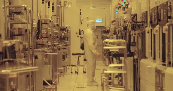 Trabajadores con trajes limpios en una instalación de fabricación de semiconductores — Vídeos de Stock