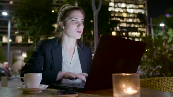 Mujer de negocios trabajando en un portátil y haciendo llamadas telefónicas — Vídeo de stock