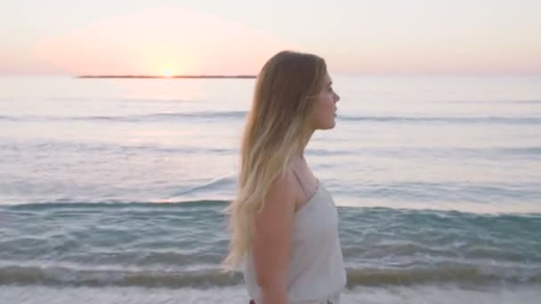 일몰 시는 해변에 산책 하는 아름 다운 여자 — 비디오