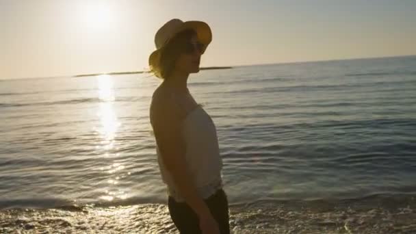 Mujer caminando en la playa al atardecer — Vídeos de Stock