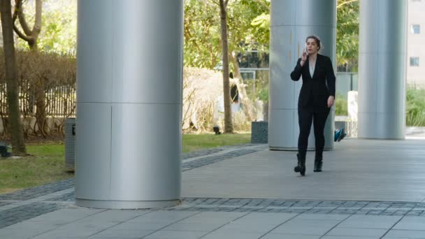 Mujer de negocios caminando en una calle — Vídeos de Stock