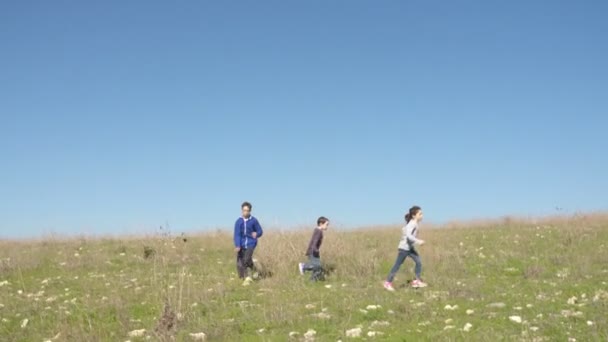 Steadycam foto de tres niños corriendo en un prado — Vídeos de Stock