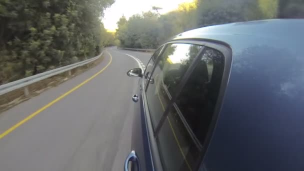 Un coche azul conduciendo a alta velocidad en una carretera curva — Vídeo de stock