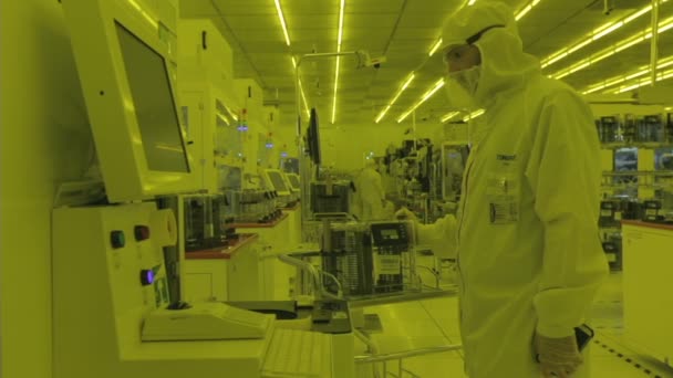 Trabajadores con trajes limpios en una planta de fabricación de semiconductores — Vídeos de Stock