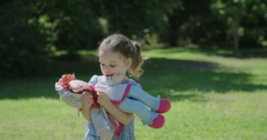 Bir bebekle oynarken mavi bir elbise ile küçük kız