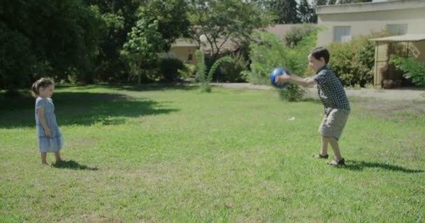 Um menino e uma menina brincando ao ar livre com um b azul — Vídeo de Stock