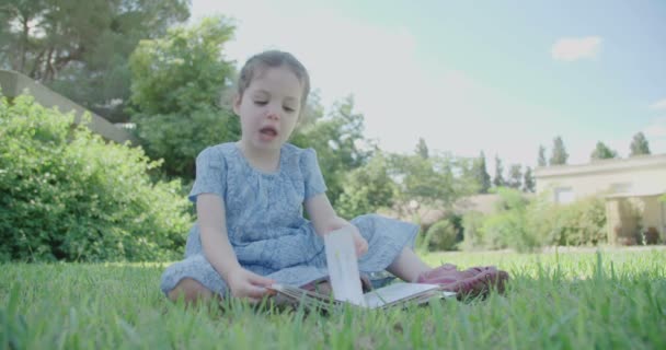 Malá holčička čtení dětská kniha venku
