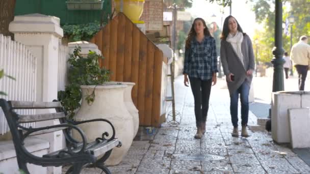 Två tjejer gå på stadens gator — Stockvideo