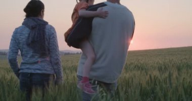 Veliler bir alanda gün batımına doğru genç kızları ile yürüme