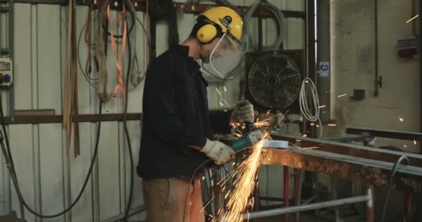 Рабочий шлифовальный металл с циркулярной пилой в мастерской — стоковое видео