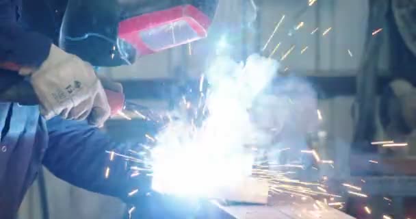 Soudeur soudant des pièces métalliques dans un atelier de soudage — Video