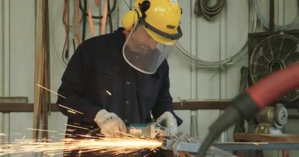 Arbetaren slipning metall med en cirkelsåg i en workshop — Stockvideo