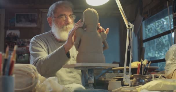 Antiguo artista modela una escultura de arcilla en un pequeño estudio — Vídeos de Stock