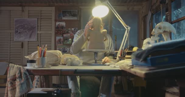 Artista antigo modela uma escultura de barro em um pequeno estúdio — Vídeo de Stock