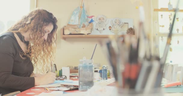 Artist painting with water colors and pencils in her studio — Stock Video