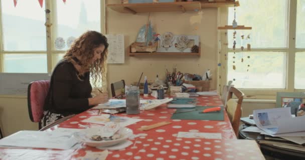 Konstnär målar med vatten färger och pennor i hennes studio — Stockvideo