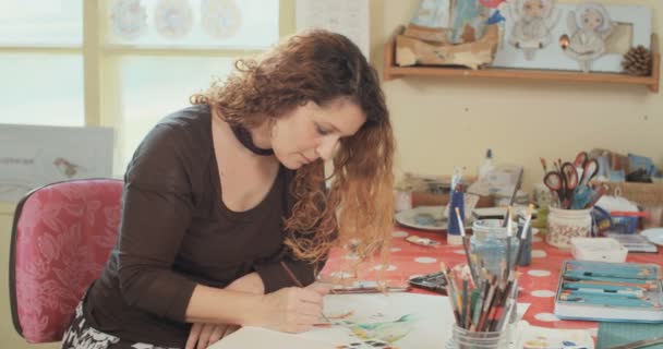 Καλλιτέχνη ζωγραφική με χρώματα του νερού και μολύβια στο στούντιο της — Αρχείο Βίντεο