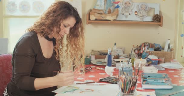 Pintura artística con acuarelas y lápices en su estudio — Vídeo de stock