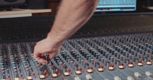 Sound engineer working with a mixing console in a recording studio — Stock Video