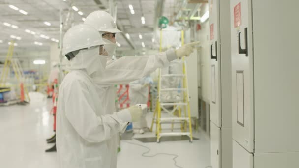 Arbeiter in sauberen Anzügen in einer Halbleiterfabrik — Stockvideo