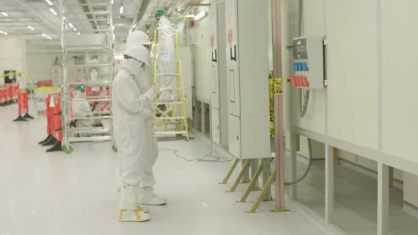 Lavoratori in tute pulite in un impianto di produzione di semiconduttori — Video Stock