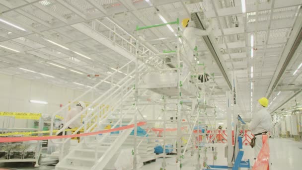 Trabajadores con trajes limpios en una planta de fabricación de semiconductores — Vídeos de Stock