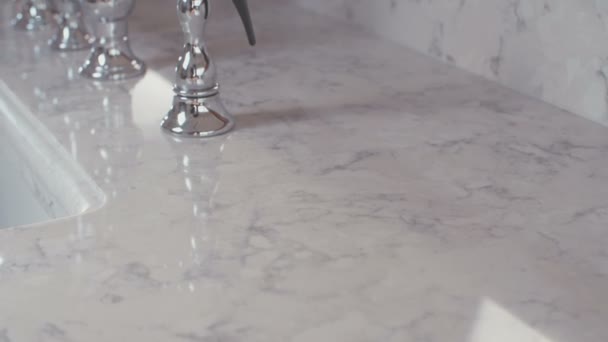 Sledování snímku luxusní kohoutek na povrchu bílé žuly — Stock video