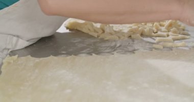 Tereyağlı kurabiye kesmek için bir çerez kesici kullanarak Baker