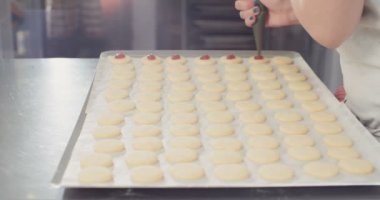 Baker çilek reçeli koyarak tereyağı kurabiye