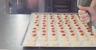 Baker çilek reçeli koyarak tereyağı kurabiye