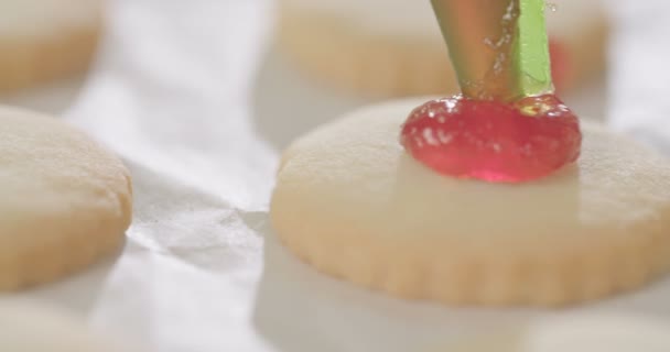 Baker poniendo mermelada de fresa sobre galletas de mantequilla — Vídeos de Stock