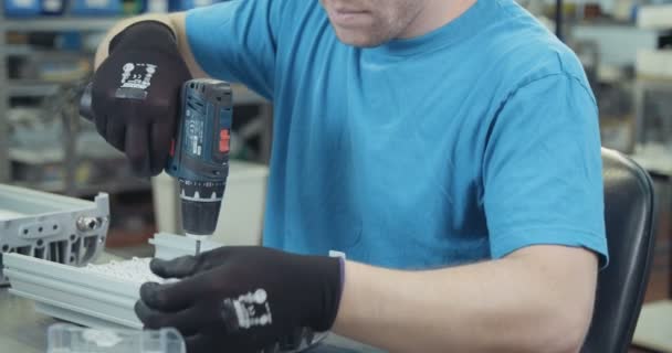 A worker assembling LED lamps in a production facility — Stock Video