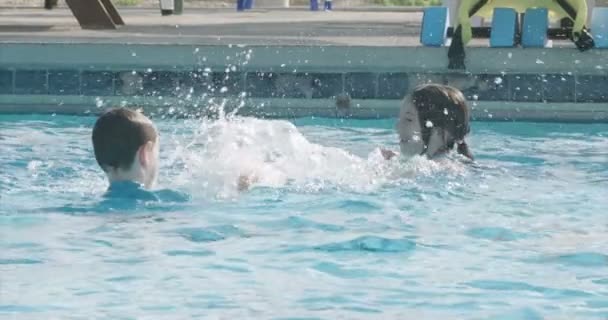 Niño y niña en la piscina — Vídeos de Stock