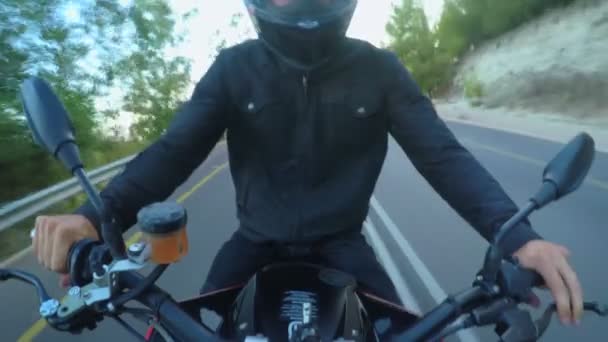 Vista panorámica de una motocicleta deportiva conduciendo a alta velocidad en un camino rural curvado — Vídeo de stock