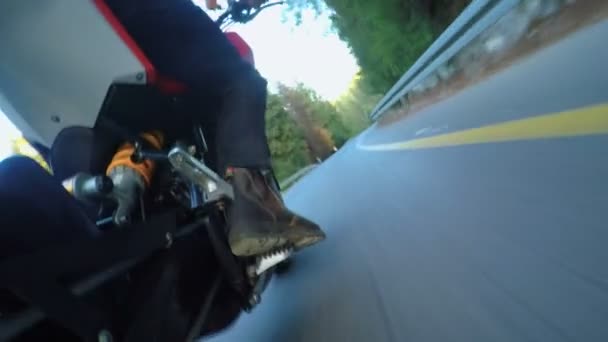 Vista panorámica de una motocicleta deportiva conduciendo a alta velocidad en un camino rural curvado — Vídeos de Stock