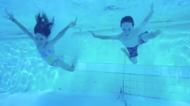 Sualtı çekim atlama ve bir yüzme havuzunda dalış iki çocuk