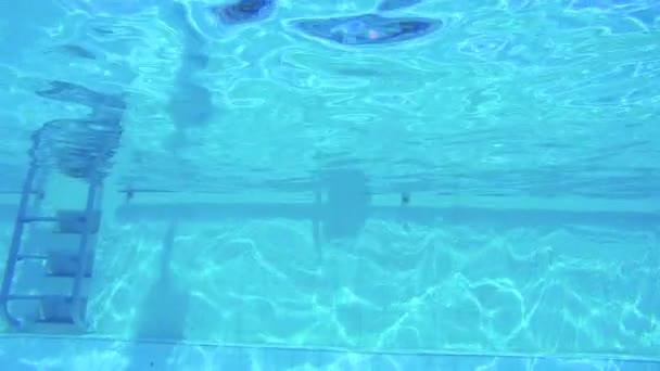 Unterwasseraufnahmen von zwei Kindern, die in einem Schwimmbad springen und tauchen — Stockvideo